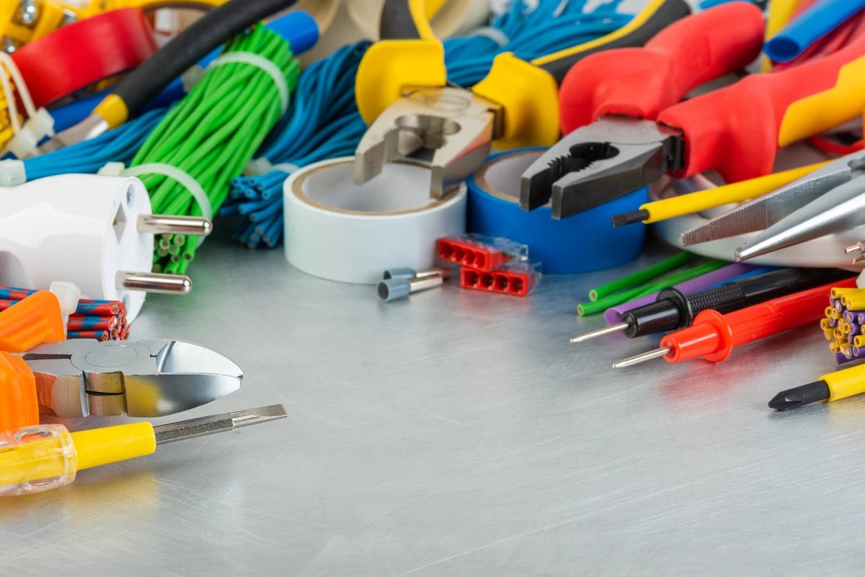 Atelier d'électricien avec outils professionnels disposés sur surface métallique