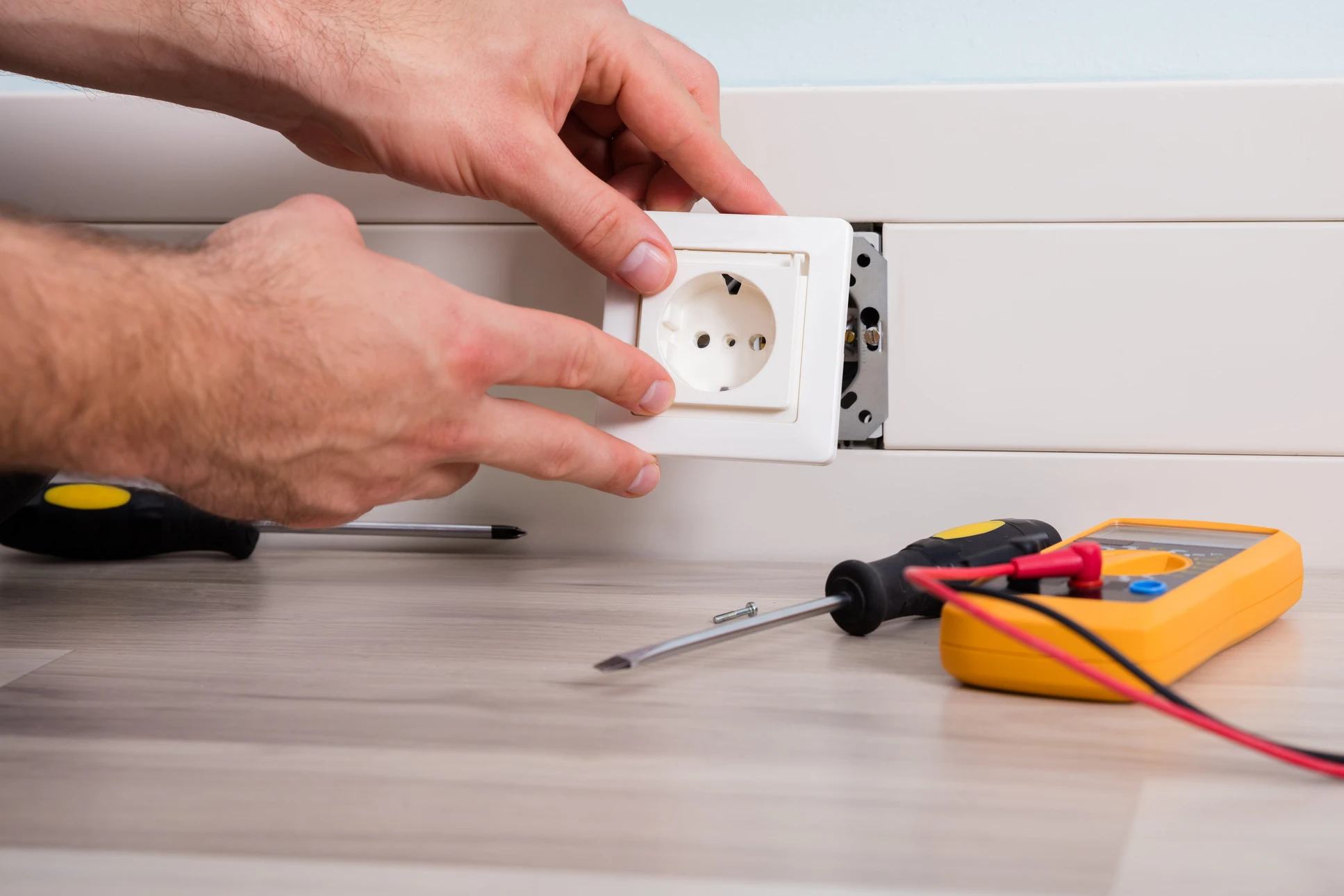 Intérieur résidentiel, main d'une personne actionnant un disjoncteur électrique dans un tableau de distribution domestique