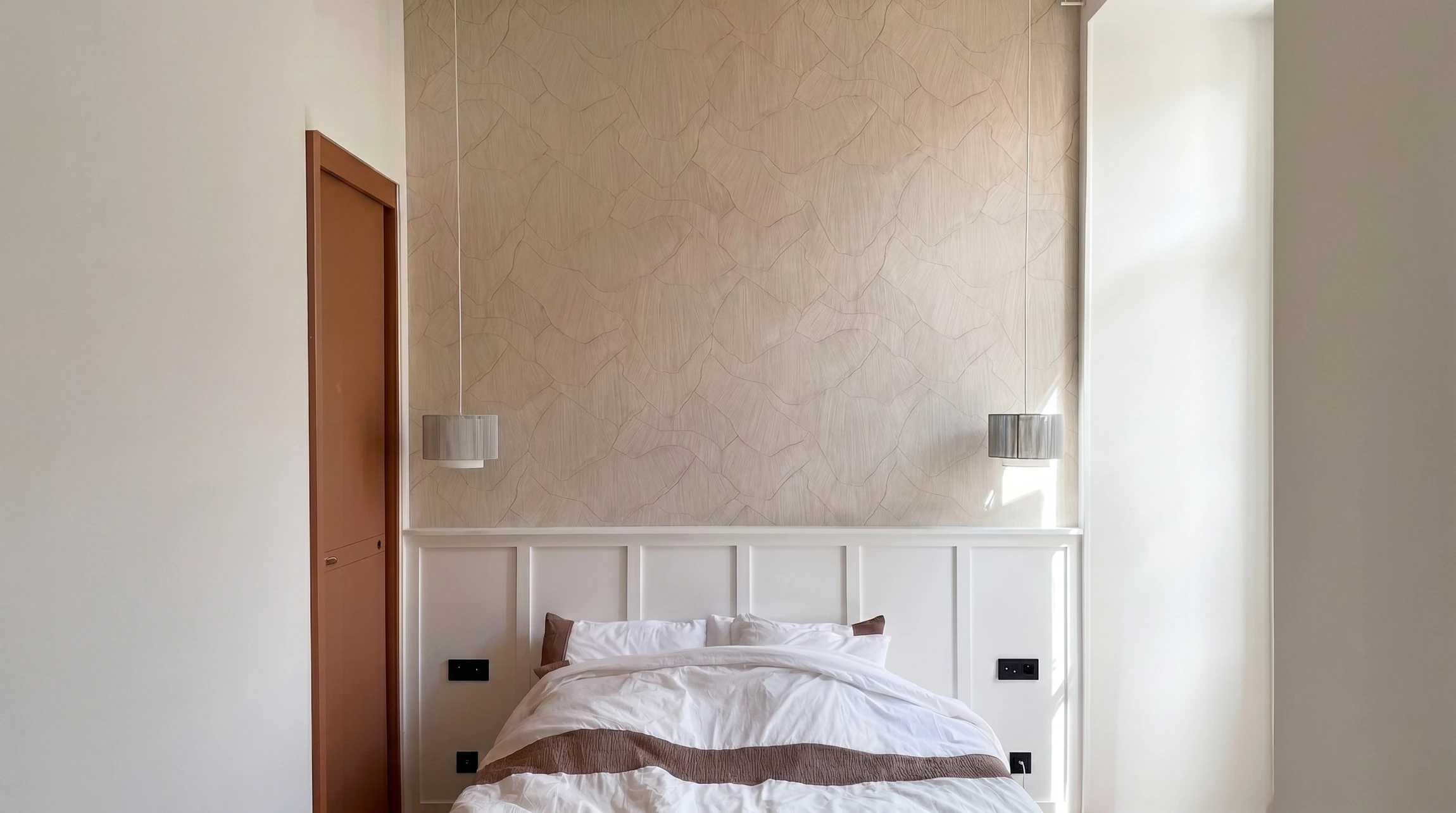 Un &eacute;lectricien installe une prise &eacute;lectrique murale blanche dans un int&eacute;rieur moderne