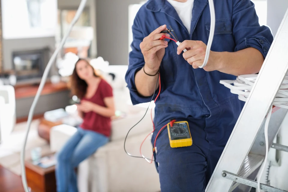 Électricien utilisant un tournevis pour pousser le câble électrique dans le Brise